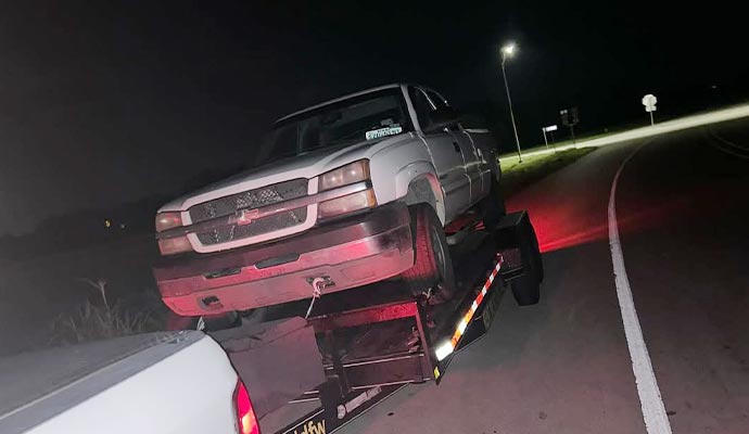 Car hauling service at night for vehicle transport Car being hauled on a trailer on the road at night